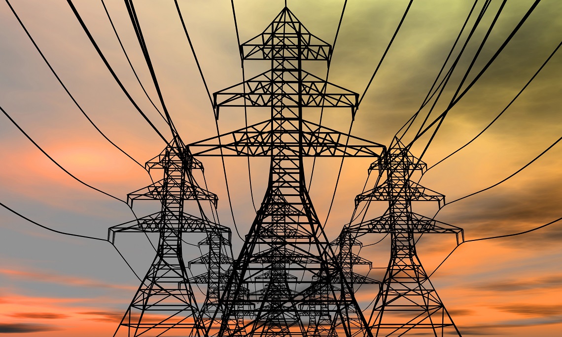 Energy pylons, transmitting electricity, on a sunset background